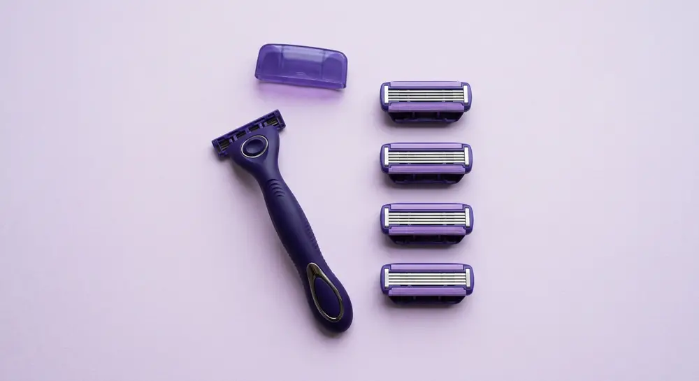 Equal Edge razor handle, travel cap and four refill cartridges laid out on lavender